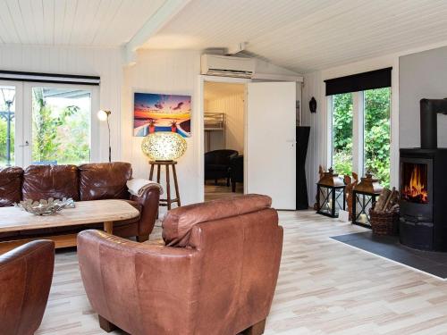a living room with leather furniture and a fireplace at 8 person holiday home in Dannemare-By Traum in Dannemare
