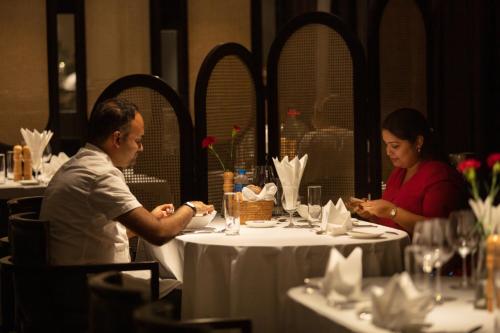 a man and woman sitting at a table in a restaurant at Scarlet Pearl Cruises - Wonder On Lan Ha Bay in Ha Long