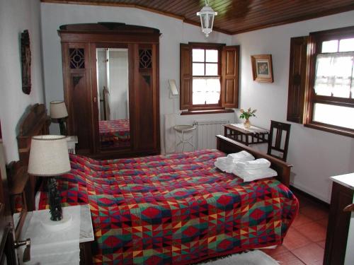 1 dormitorio con 1 cama con un edredón colorido en Casa Rosinha Menor, en Riba de Âncora