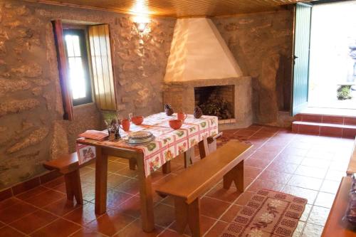 comedor con mesa y chimenea en Casa da Eira- into the Nature, en Macieira de Alcoba