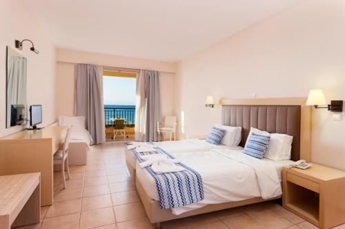 a hotel room with a large bed and a desk at Alykanas Village Resort in Alikanas