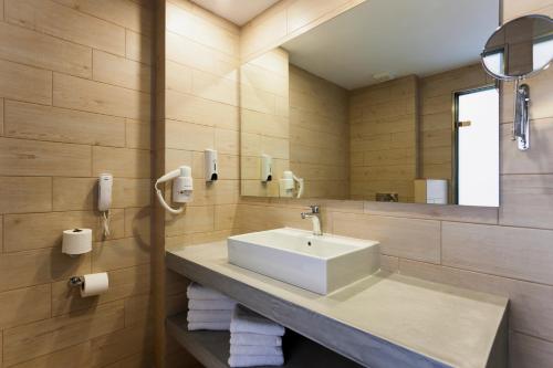 a bathroom with a sink and a mirror at Alykanas Village Resort in Alikanas