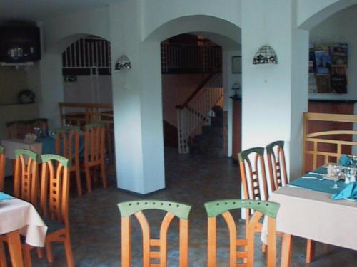 uma sala de jantar com mesas e cadeiras e uma escadaria em Hotell De Tolly em Tõrva