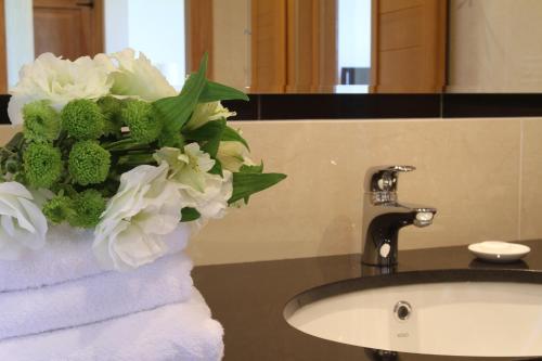 a vase of flowers sitting on a bathroom sink at Hotel Zamek Bobolice in Niegowa