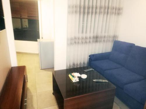 a living room with a blue couch and a coffee table at سما عمان للشقق الفندقية Sama Amman Hotel Apartments in Amman
