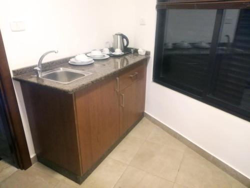 a small kitchen with a sink and a window at سما عمان للشقق الفندقية Sama Amman Hotel Apartments in Amman