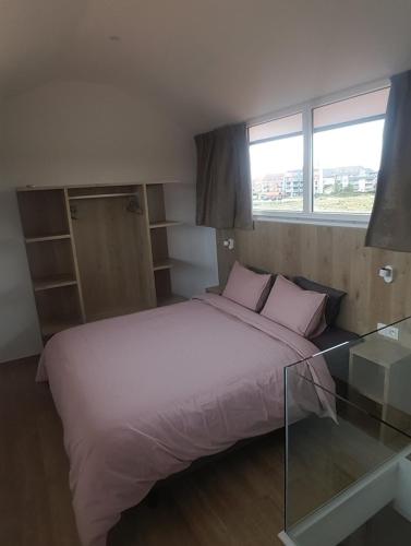 Schlafzimmer mit einem großen Bett und einem Glastisch in der Unterkunft Huisje aan zee in Middelkerke