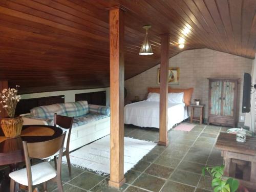 um quarto com uma cama, uma mesa e cadeiras em Suite da Fernanda em Vila Velha