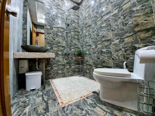 La salle de bains en pierre est pourvue de toilettes et d'un lavabo. dans l'établissement Kaiyana Boracay Beach Resort, à Boracay