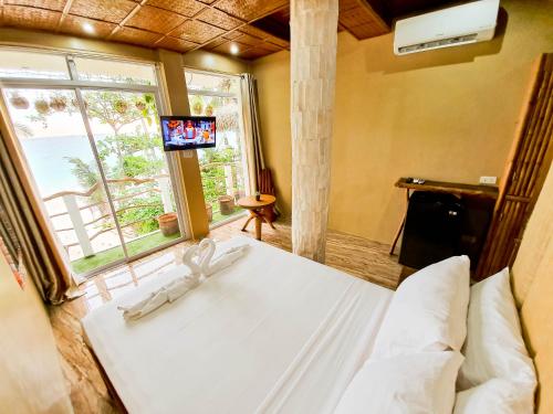 a bedroom with a bed and a tv in a room at Kaiyana Boracay Beach Resort in Boracay