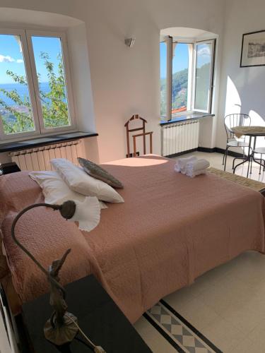 a bedroom with a large bed with windows at Villa Rocca Leivi in Leivi