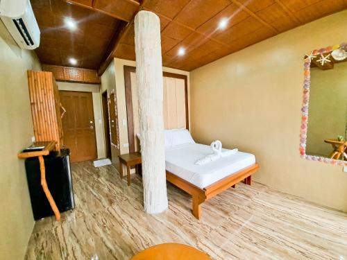 a bedroom with a bed and a column in it at Kaiyana Boracay Beach Resort in Boracay