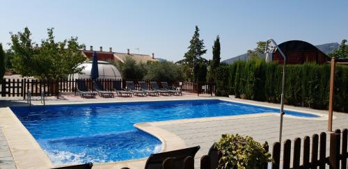 a swimming pool with blue water in a yard at Alojamientos Casa Ruiz in Archivel