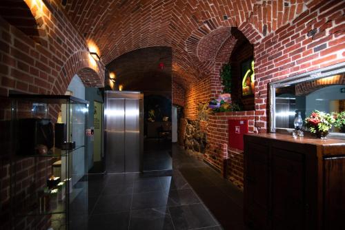 a room with a red brick wall and a refrigerator at Zamek Gniew - Pałac Marysieńki in Gniew