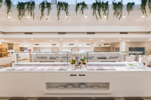 a large kitchen with plants hanging from the ceiling at Esperides Beach Resort in Faliraki