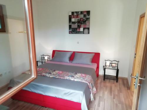 Un dormitorio con una cama roja y azul y un espejo en hostel Stalno Sretan en Labin