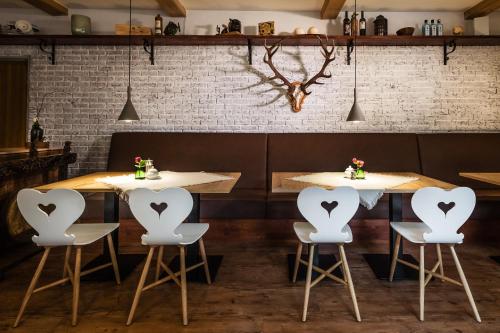 a restaurant with three white chairs with hearts on them at Das Halali - dein kleines Hotel an der Zugspitze in Ehrwald