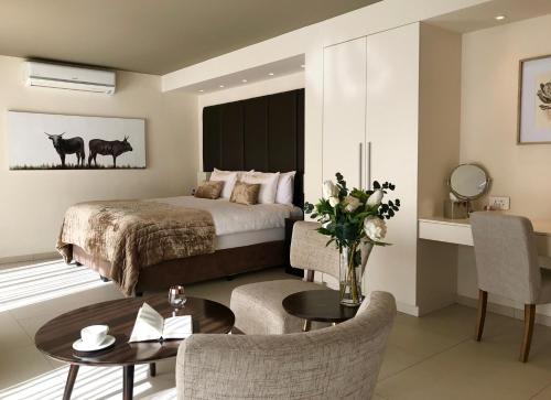 sypialnia z łóżkiem, stołem i krzesłami w obiekcie Cape Vermeer w mieście Somerset West