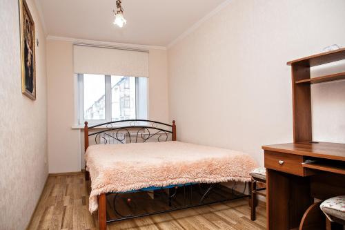 a bedroom with a bed and a window at KemHotel Квартирное Бюро in Kemerovo