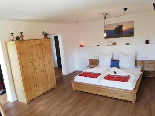 una camera con un letto con due cuscini rossi di Appartement Alpblick a Sonthofen