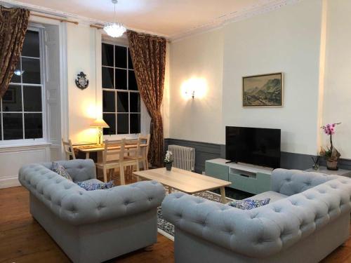 愛丁堡的住宿－City Centre En-Suite Room，客厅配有两张沙发和一台电视