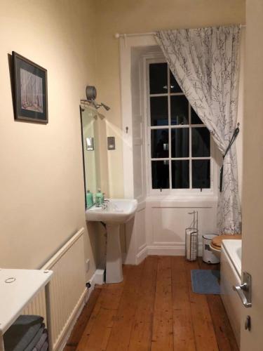 a bathroom with a sink and a window at City Centre En-Suite Room in Edinburgh