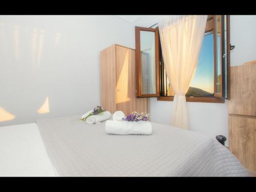 a bedroom with a bed with towels and a window at CHEZ KONSTANTINOS in Kallirakhi