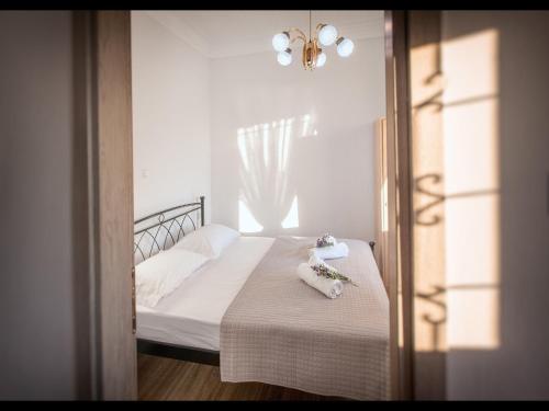 a bedroom with a bed with white sheets and a mirror at CHEZ KONSTANTINOS in Kallirakhi