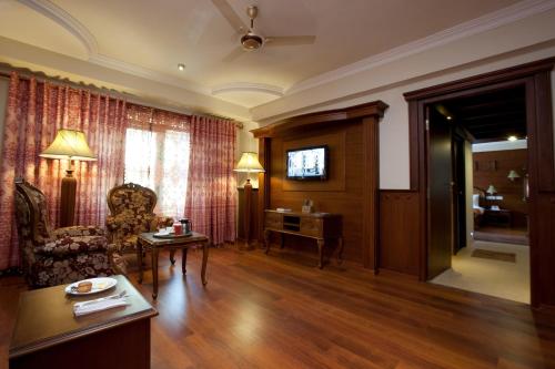 a living room with a couch a chair and a table at JC Residency Madurai in Madurai