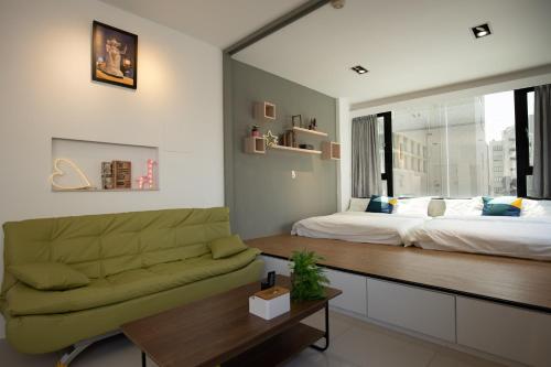 uma sala de estar com uma cama e um sofá em YouI98 Guesthouse一層一戶大坪數套房#本國旅客須先匯款 em Tainan