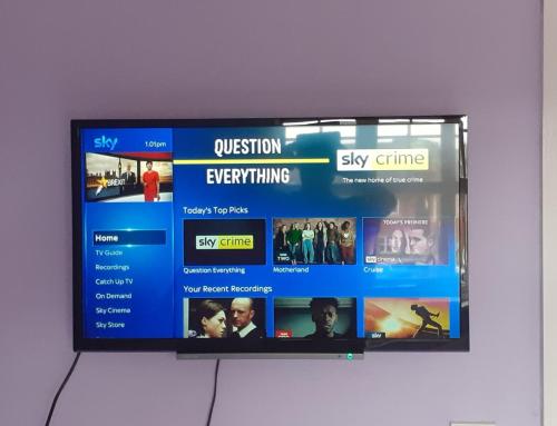 TV de pantalla plana colgada en la pared en Double Room in Honiton House, en Hendon