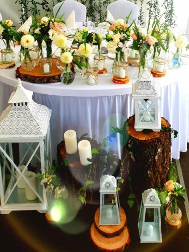 a table with candles and lanterns on a tree stump at 4 Żywioły Falenty Ośrodek Konferencyjno-Szkoleniowy in Raszyn