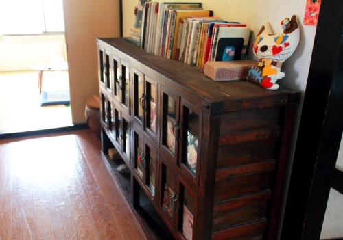 a wooden book shelf filled with books in a room at Oyado Hana in Nachikatsuura