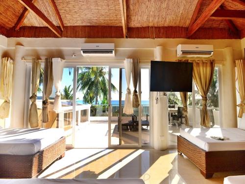 a bedroom with two beds and a flat screen tv at Kaiyana Boracay Beach Resort in Boracay