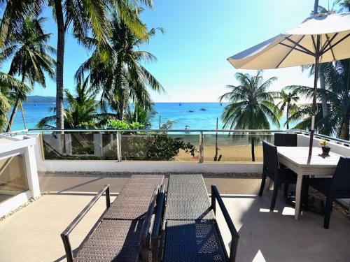 a balcony with a table and a view of the ocean at Kaiyana Boracay Beach Resort in Boracay