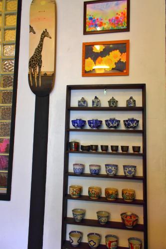 a shelf of ceramics with a giraffe on it at Oyado Hana in Nachikatsuura