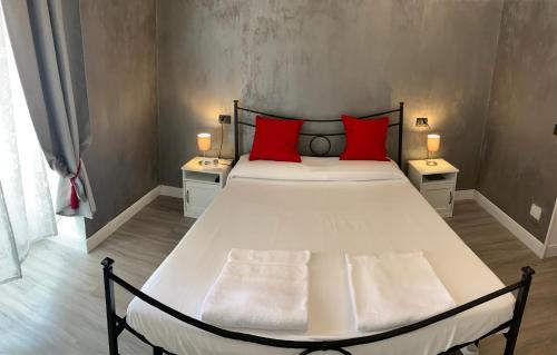 una camera da letto con un grande letto con cuscini rossi di Affittacamere Virginia's Rooms a Genova