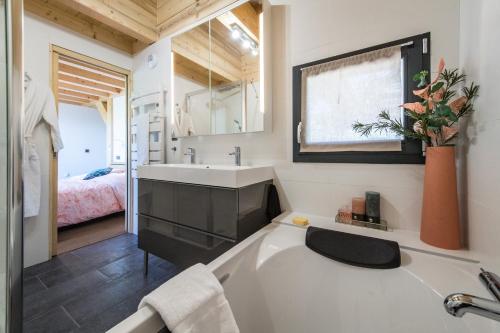 Un baño con bañera, lavabo y cama. en Harfang des Neiges, en La Toussuire