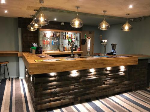 a bar with a wooden counter and lights at Pentire Newquay Cornwall Hotel in Newquay