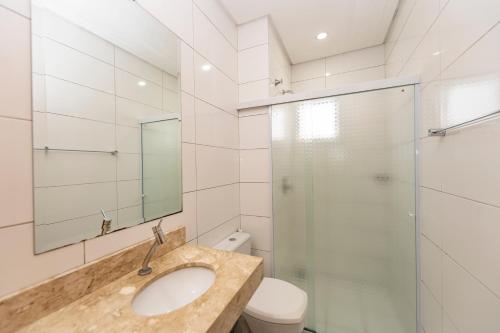 a bathroom with a sink and a glass shower at Hotel Tainá - Aeroporto Cuiabá in Várzea Grande