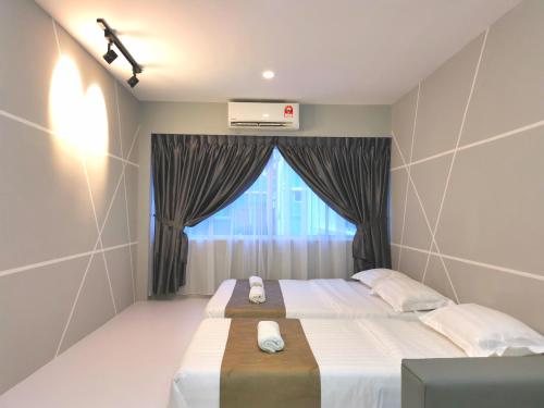 a bedroom with two beds and a window at HotSpot @ City Centre by SSVC in Kota Kinabalu