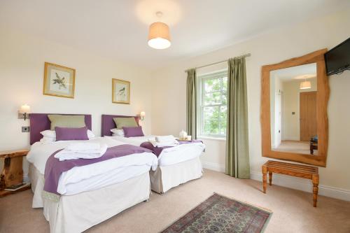 a bedroom with two beds and a mirror at Countryside Escape - The Night Owl in Alnwick