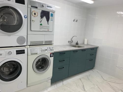 a laundry room with a washer and dryer and a sink at Suecia Villa Opal Anfi Tauro in Mogán