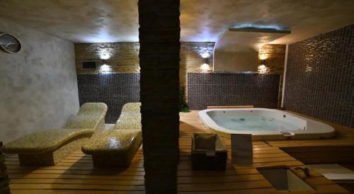 ein großes Badezimmer mit Badewanne und zwei Stühlen in der Unterkunft Apartman Planinski raj in Kopaonik