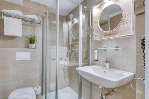 a bathroom with a sink and a shower at Hotel Strandschlösschen in Travemünde