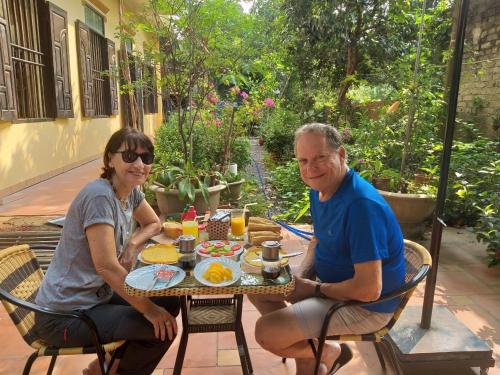 a man and woman sitting at a table with food at Lys Homestay in Ninh Binh