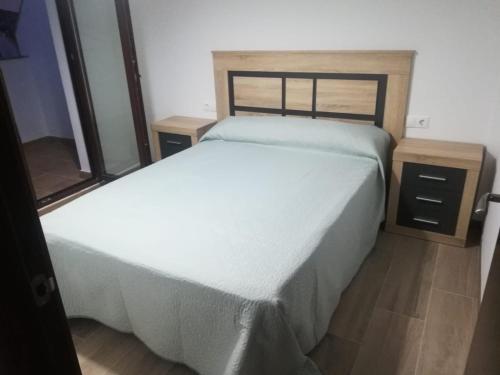 1 dormitorio con cama blanca y mesita de noche en Apartamentos Buena Vista 1, en Coto Ríos