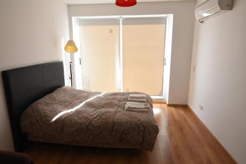 a bedroom with a bed and a large window at Roca 771 Apartment in Buenos Aires