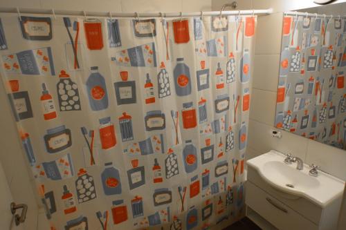 y baño con cortina de ducha, aseo y lavamanos. en Roca 771 Apartment en Buenos Aires