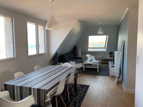 uma sala de jantar e sala de estar com mesa e cadeiras em Appartement Design II - Port du Rosmeur -Douarnenez em Douarnenez